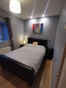 una camera da letto con un letto e un dipinto sul muro di Cosy 1 bedroom cottage, Ideal quiet getaway. a Creeslough