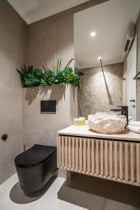 a bathroom with a black tub and a sink at Blanche Cliff Apartments in Sveti Stefan
