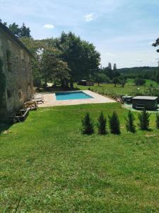 um quintal com uma piscina e um edifício em Manoir Vaillant Gîte au cœur du Périgord noir em Monplaisant