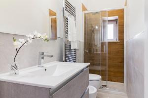 La salle de bains blanche est pourvue d'un lavabo et d'une douche. dans l'établissement Magia Marmore, à Terni