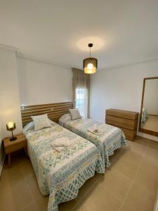 a bedroom with two beds and a mirror at PLAZAMAYOR in Calpe