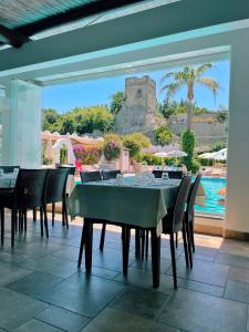 comedor con mesa, sillas y piscina en Hotel Lord Byron, en Isquia