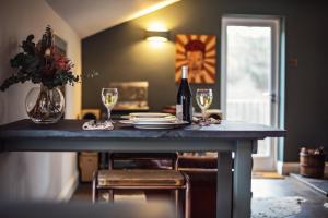 a table with a bottle of wine and two glasses at Black Mountains Stylish Hideaway, nr Crickhowell in Llanbedr