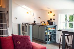 a kitchen with a red couch in a room at Black Mountains Stylish Hideaway, nr Crickhowell in Llanbedr