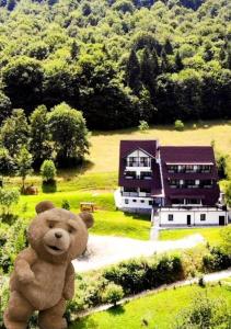 a teddy bear is standing in front of a house at Pensiunea Ursuleț Bran in Bran
