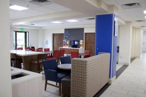 a restaurant with chairs and tables and a blue pillar at Holiday Inn Express & Suites Wilson-Downtown by IHG in Wilson