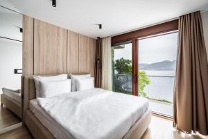 a bedroom with a large bed with a large window at Blanche Cliff Apartments in Sveti Stefan