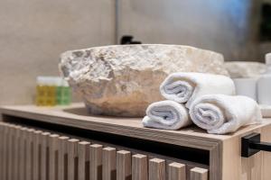 a counter with towels and a large rock at Blanche Cliff Apartments in Sveti Stefan