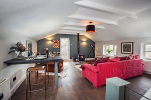 a living room with a red couch and a table at Black Mountains Stylish Hideaway, nr Crickhowell in Llanbedr