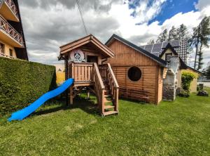 una pequeña casa de juegos de madera con un sneper azul en Szostak Apartament, en Bańska Niżna