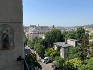 Panoramic Hideaway in Central Buda في بودابست: اطلالة على شارع المدينة مع وجود تمثال على مبنى