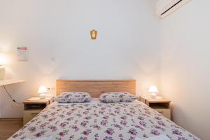 a bedroom with a bed and two lamps on two tables at Room Laudina in Cres