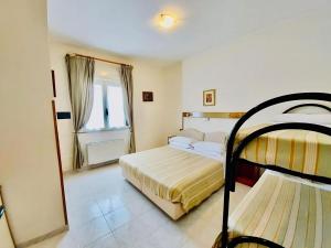 una camera con due letti a castello e uno specchio di Albergo delle Rose a Bagnara Calabra