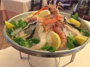 a plate of food with lobster and lemon slices at Il Castello in Villaputzu