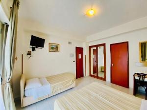 una camera da letto con un letto e una TV di Albergo delle Rose a Bagnara Calabra