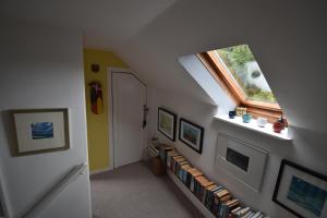 a hallway with a book shelf with books at Yewtree Cottage - 'The Art House' and Garden in Hunters Quay