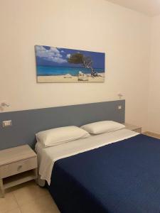 1 dormitorio con 1 cama y una pintura en la pared en Villa D'Angelo, en Ascea
