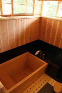 a bathroom with a wooden tub with a sink at Chiiori in Miyoshi