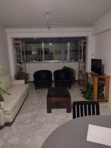 ein Wohnzimmer mit einem Sofa, Stühlen und einem Tisch in der Unterkunft Garibaldi in Mendoza