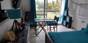 a room with a bed and a table and chairs at Gwada STUDIO VUE MER in Le Gosier