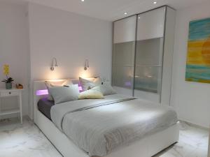 a white bedroom with a large bed in a room at NIDO DEL AMOR deluxe 1a linéa Terraza Indoorpool Wifi Aire Netflix 10 metros a Cala del Pino in La Manga del Mar Menor