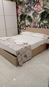 łóżko z białą pościelą i poduszkami w pokoju w obiekcie Nase e cane home Napoli w mieście Napoli