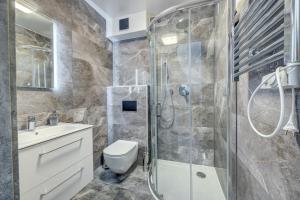 a bathroom with a shower and a toilet and a sink at Apartamenty 111 in Pobierowo