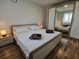 a bedroom with a large bed and a large mirror at Apartmani Peco Duće in Duće