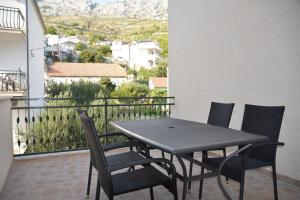 a black table and chairs on a balcony at Apartmani Peco Duće in Duće