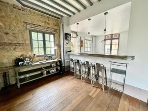 a kitchen with a bar and some chairs at Villa au bord de la mer à Benerville in Bénerville-sur-Mer