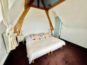 a bedroom with a bed in an attic at Villa au bord de la mer à Benerville in Bénerville-sur-Mer