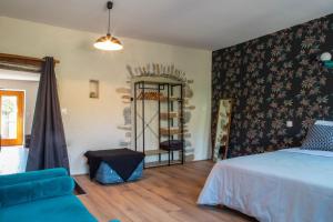 a bedroom with a bed and a chair in a room at Passage en Paradis in Arbois