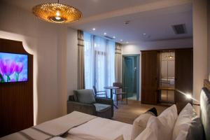 a hotel room with a bed and a chair at New Egreta Resort in Dunavăţu de Jos