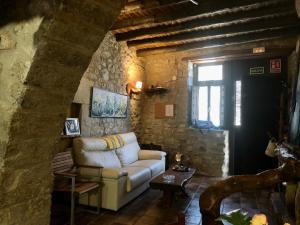 un soggiorno con divano bianco e parete in pietra di Casa Rustic Suites, JACUZI & LOVE a Xert