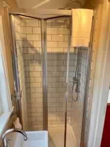 La salle de bains est pourvue d'une douche avec une porte en verre. dans l'établissement Sheelin Shepherds Hut 2 with Hot Tub, à Mountnugent