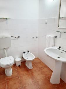 a white bathroom with a toilet and a sink at Mateus Studios in Vila Nova de Milfontes