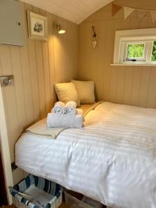 a bedroom with a bed with towels on it at Sheelin Shepherds Hut 2 with Hot Tub in Mountnugent