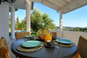 a black table with plates of food on a patio at Playia Villas III in Petrití