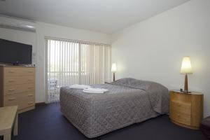 A bed or beds in a room at Burswood Lodge Apartments