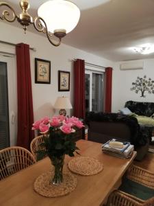 uma sala de estar com uma mesa com flores cor-de-rosa em Villa Belle Vue em Celina