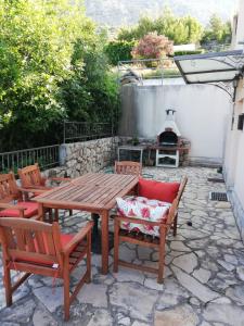 a wooden table and chairs on a stone patio at Villa Belle Vue in Čelina