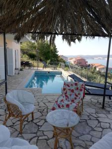 a pool with two chairs and a couch and a table at Villa Belle Vue in Čelina