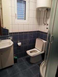 uma casa de banho com um WC, um lavatório e uma janela em Villa Belle Vue em Celina