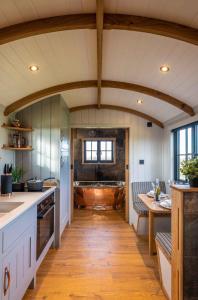 a kitchen with a sink and a tub in it at Monkwood Shepherds Hut - Ockeridge Rural Retreats in Worcester