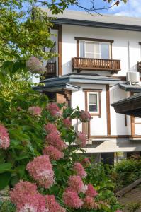 a house with pink flowers in front of it at Le Bocage - Hakuba Echoland Chalets in Hakuba