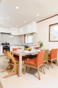 a kitchen with a wooden table and chairs at Le Bocage - Hakuba Echoland Chalets in Hakuba