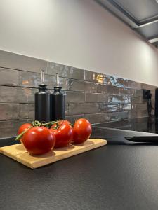 un montón de tomates en una tabla de cortar con un cuchillo en Apartmenthaus Stade Schwingewiesen Apartment 6, en Stade
