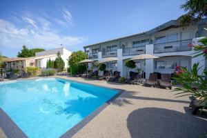a swimming pool in front of a hotel at Hôtel Le Peu Breton in Sainte-Marie-de-Ré