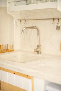 un lavandino bianco in una cucina bianca con lavandino di Argo-studios a Kinion