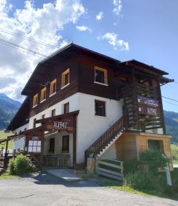 un grand bâtiment en bois avec des escaliers. dans l'établissement Hôtel le Christiania, à Arêches